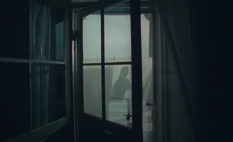 Woman hangs sheets on the clothesline strung across porch