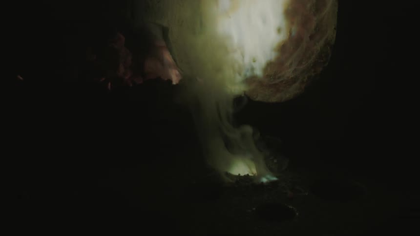 Burning metal pours from a large ladle