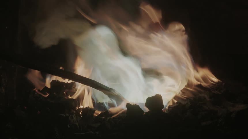 A fire is burning in a dark area