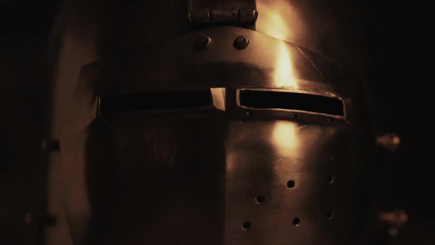 A fire is reflecting off a steel helmet