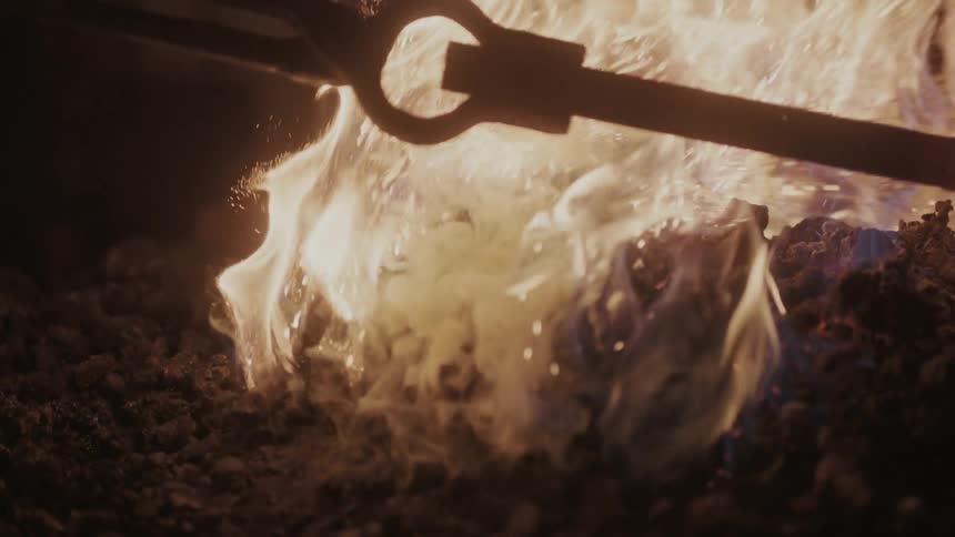 A fire burns bright as it is stirred
