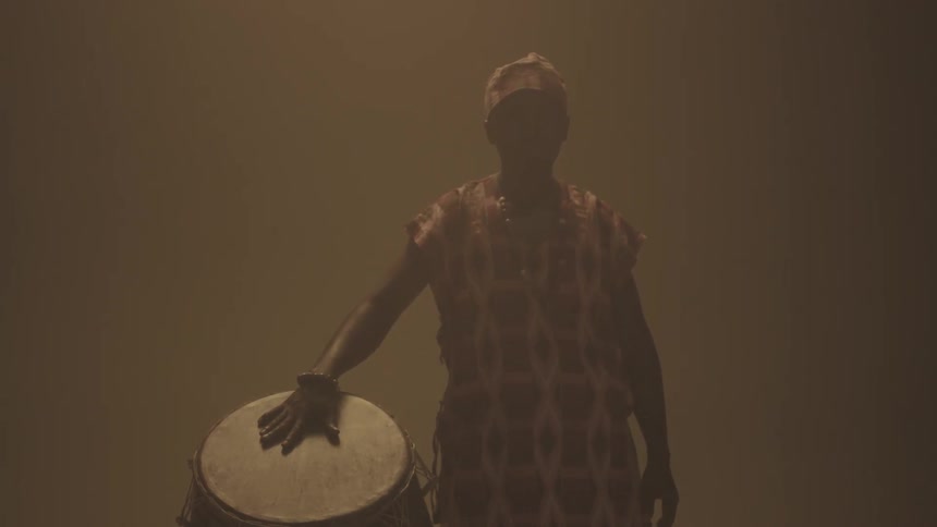 A man puts his hand on a large drum