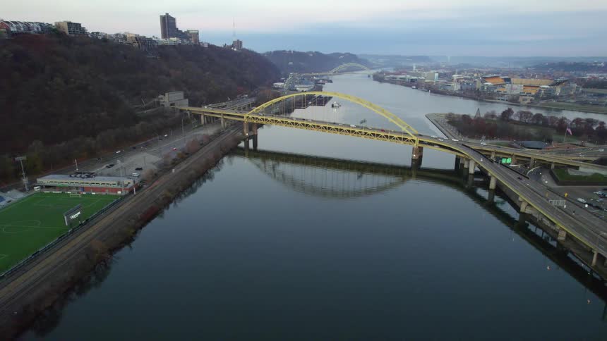 Heavy traffic passes over a bridge and a highway near a city