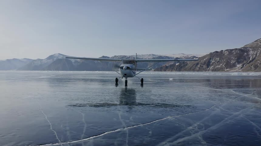 An aircraft on an iced over lake starts up its propellor