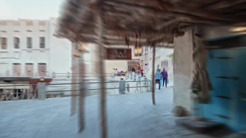 People walking through and old city on pedestrian only canopy covered streets past homes and shops