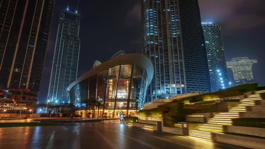 Time lapse of pedestrians in a city park in front of high rise office buildings
