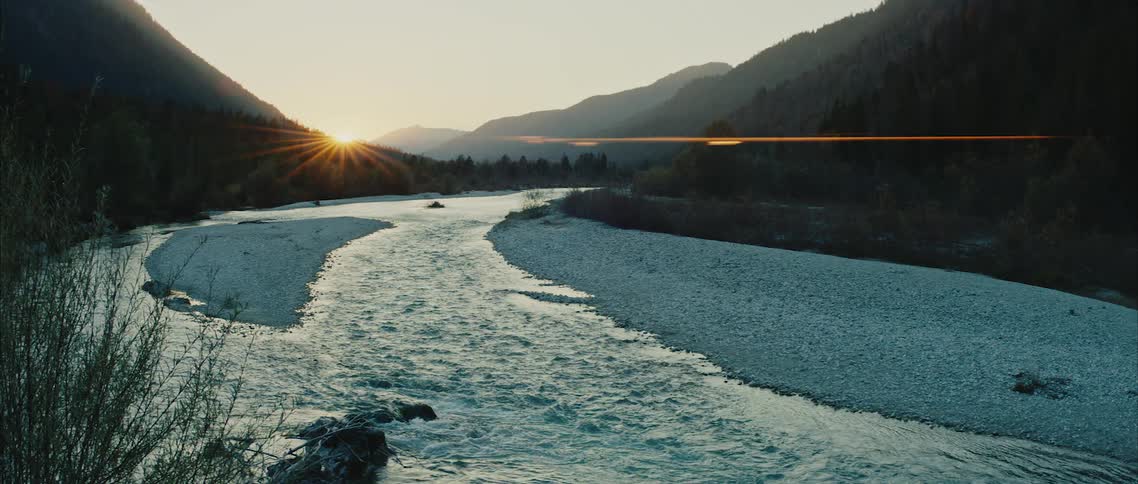 A river in the hills flowing as the sun sets