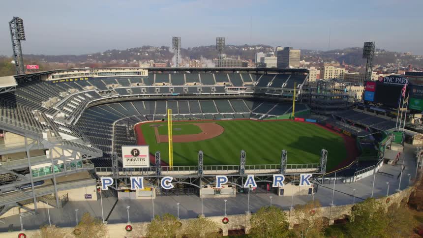 An empty pnc park in pittsburgh with bright green grass