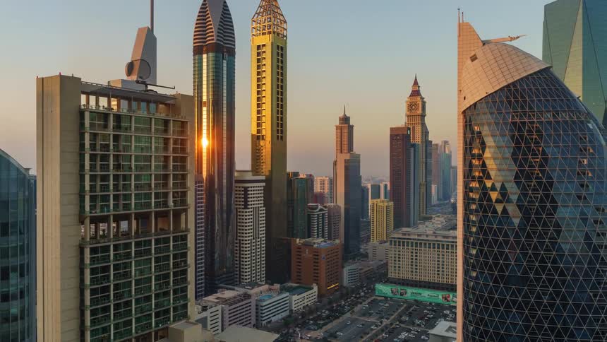 Sunlight shining on innovative building facades in dubai over traffic jammed streets