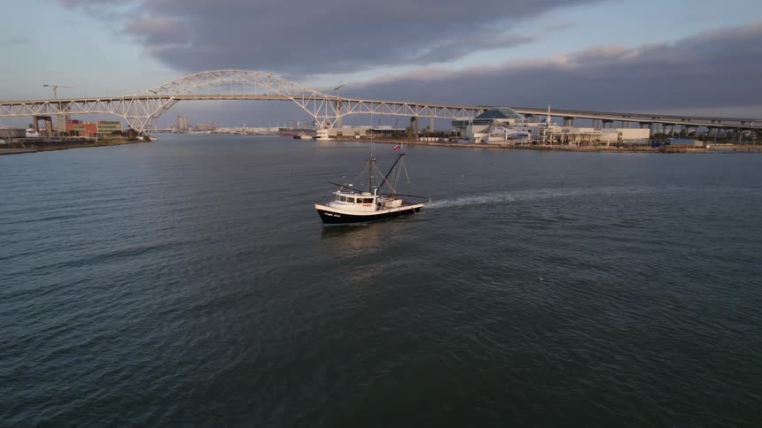 There is a boat in the water in front of the skyline in the daytime