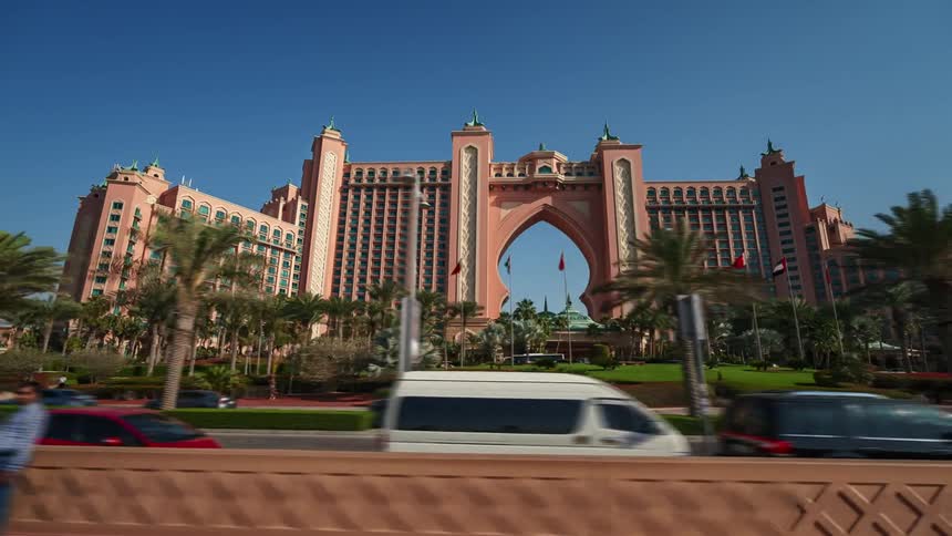Time lapse of the facade of a hotel on a busy street under a bright blue sky