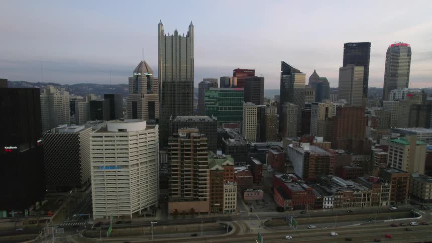 Modern buildings and skyscrapers stand tall over the metropolitan city as traffic moves on the streets