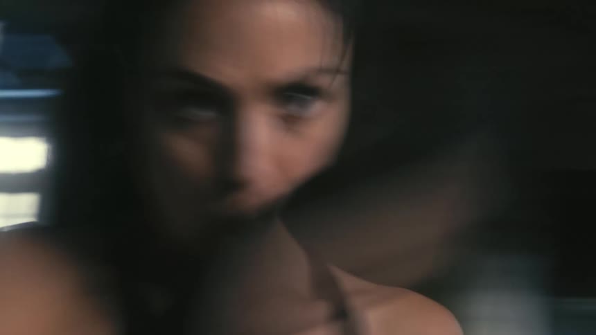 Close up of a young strong woman shadowboxing intensely inside an abandoned building