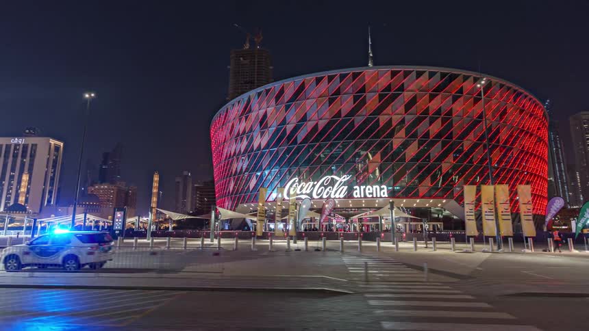 A colorful sports arena in a metropolis at night