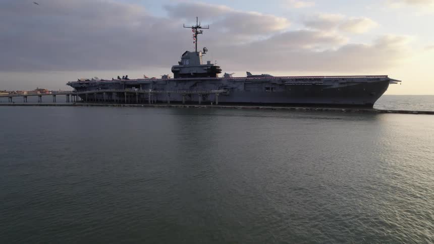 The USS Lexington aircraft carrier ship is parked at the pier in the ocean