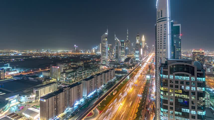Time lapse of traffic and bright lights on the streets of a futuristic skyline at night