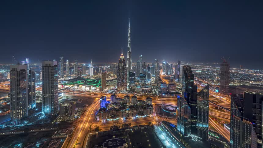 Traffic moves along bright highways near downtown at night