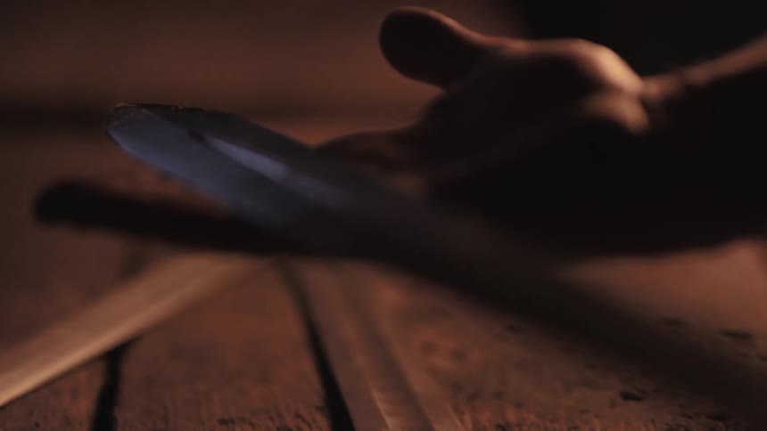 A blade is examined in a person's hand
