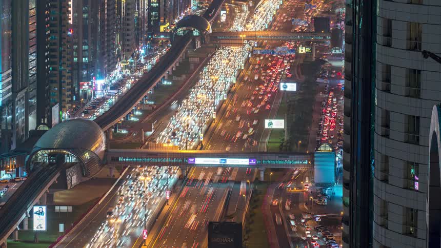 Car lights shine brightly as traffic moves on busy metropolitan streets