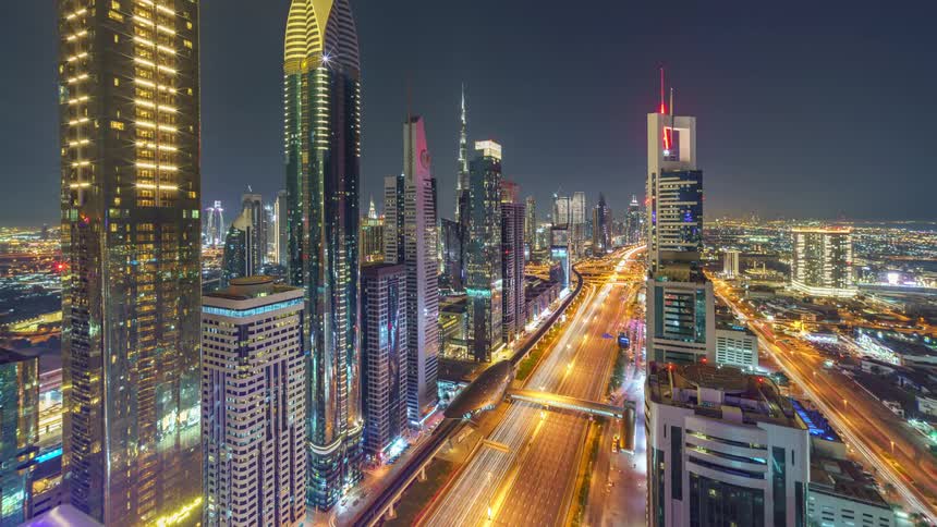 Traffic flows along roads in a large city at night