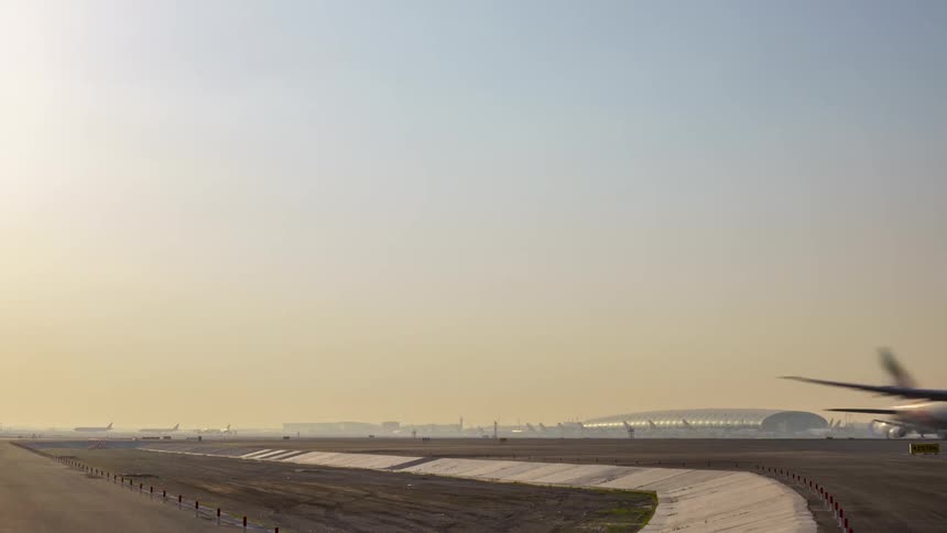 An airplane takes off from a runway as other airplane move around the airport runways