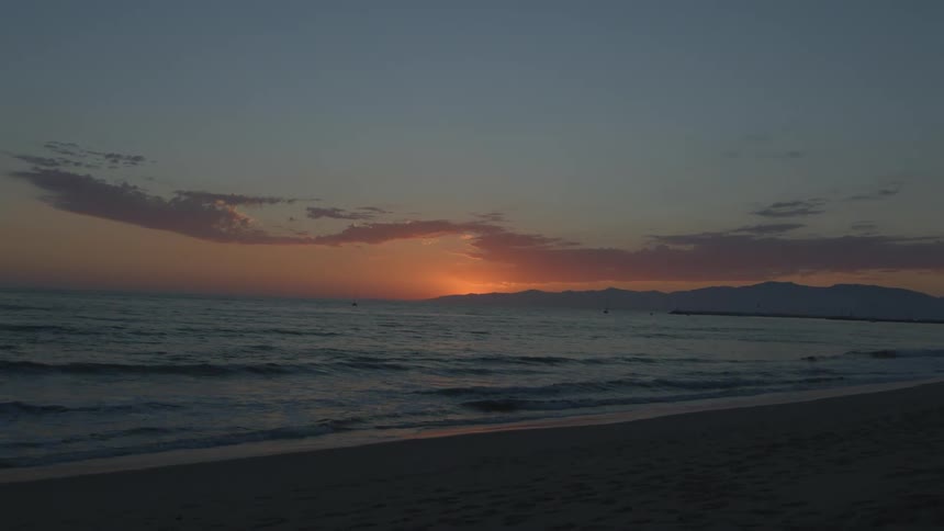 The view is of the beach and ocean as the sunset is rising