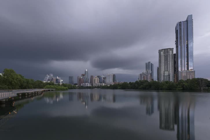Time lapse of storm clouds moving over a water way and high rise buildings