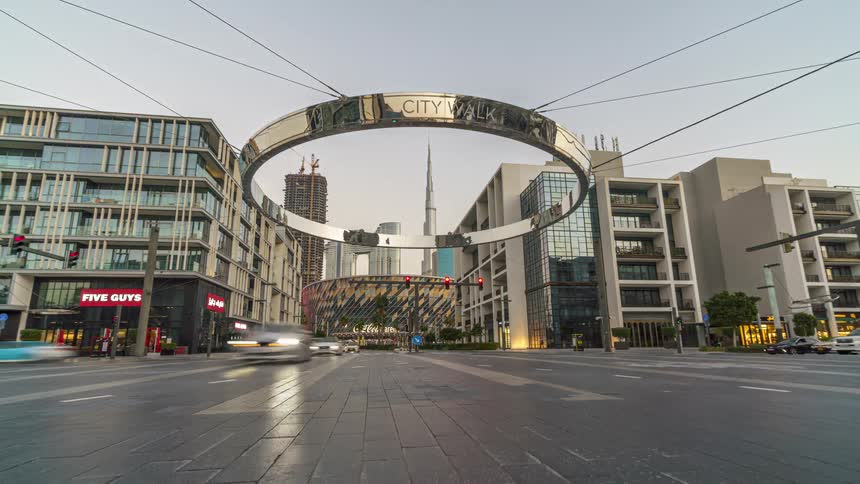 Time lapse from daylight to night of the traffic under the city walk sign on the streets of dubai