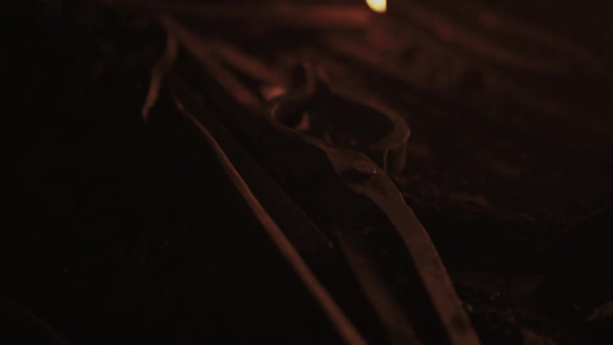 Light reflects off tools as a hot metal rod is placed down