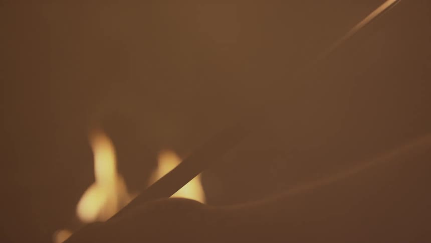 A person is examining a sword in a smokey area