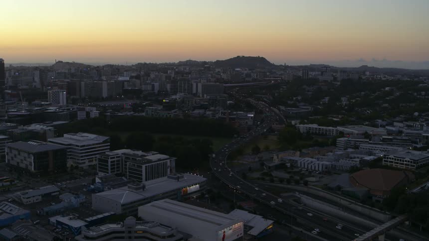 Traffic travels along a freeway through a metropolis in the evening