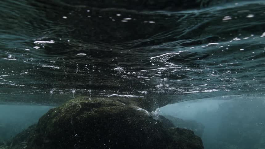 Water that moves across the surface of the sea on big rock underwater