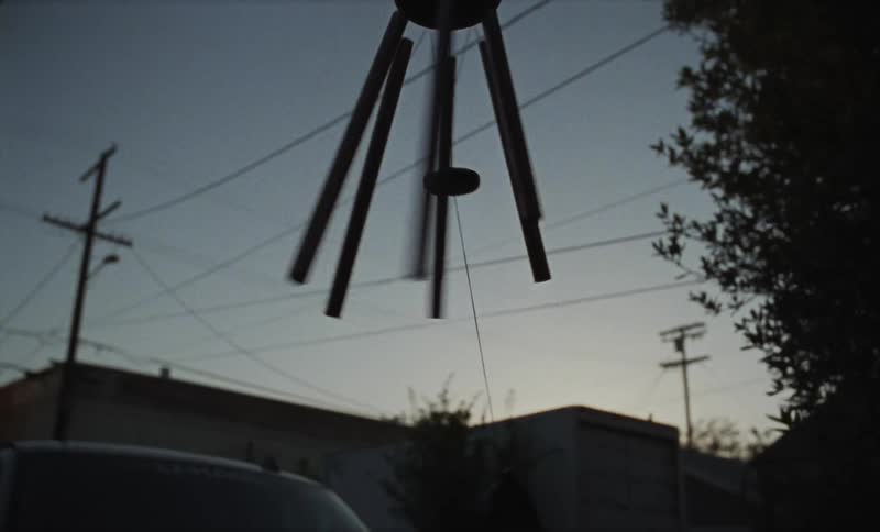 A wind chiming spinning outside on a windy evening