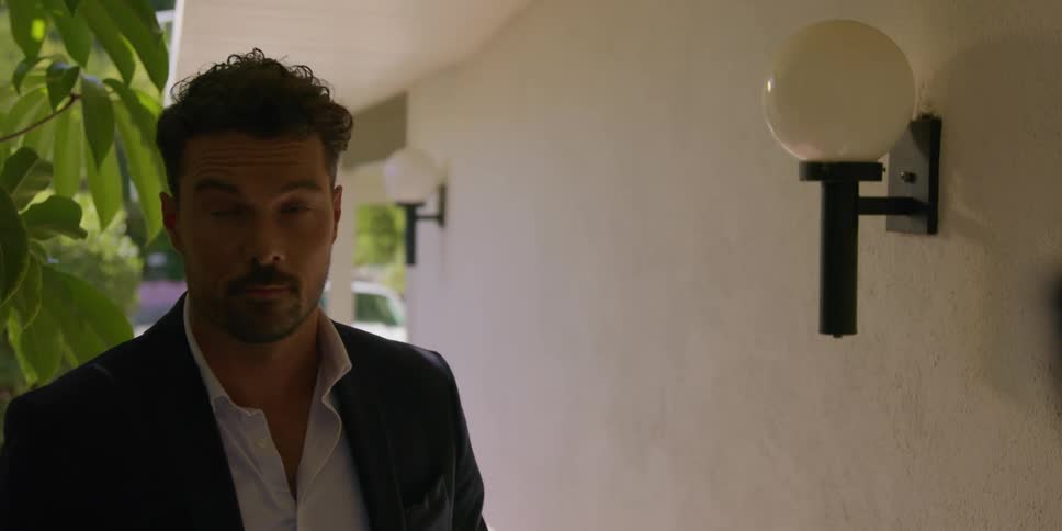 A man stands at a house and shakes a persons hand and points at the house and then turns and walks away
