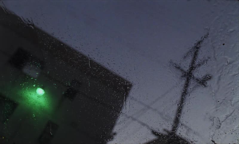 A windshield wiper operating during a rainstorm at night