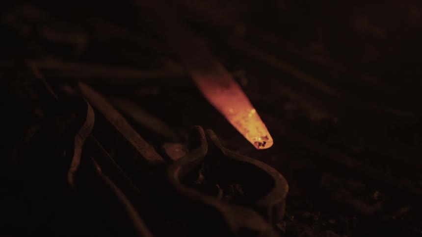 Glowing hot metal sits near some tools