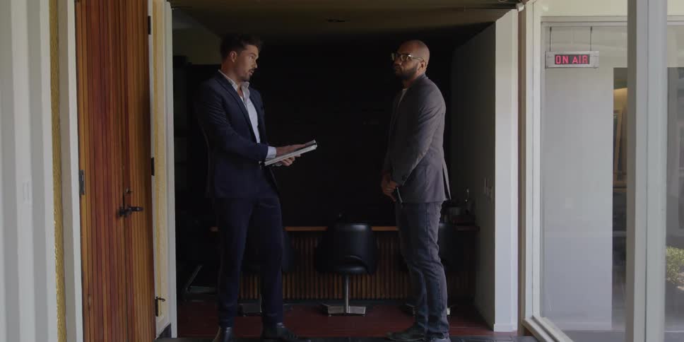 Two coworkers are talking to each other in the office room