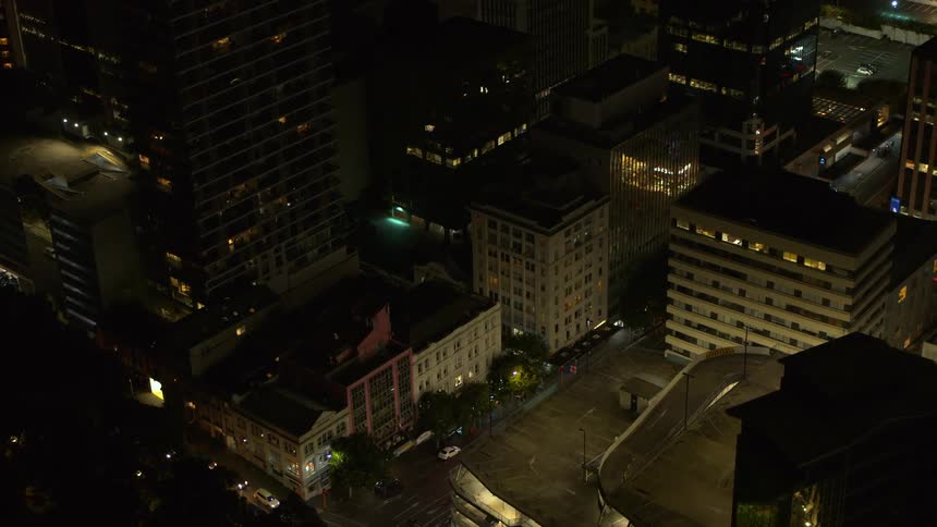 Aerial view of illuminated apartment buildings and streets in the city at night