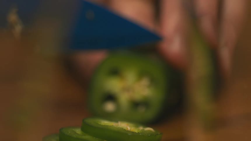 Close up of a person cutting a jalapeno