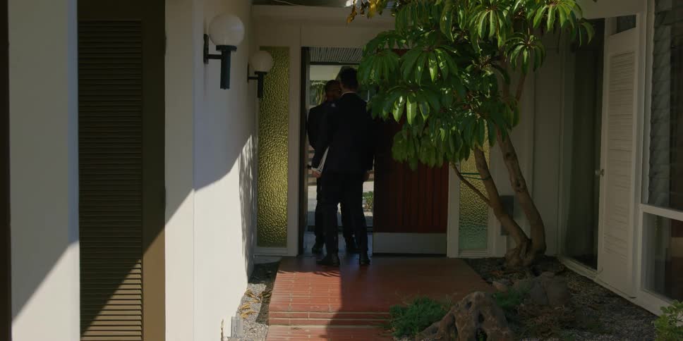 A salesman shakes hands with a client at the clients house