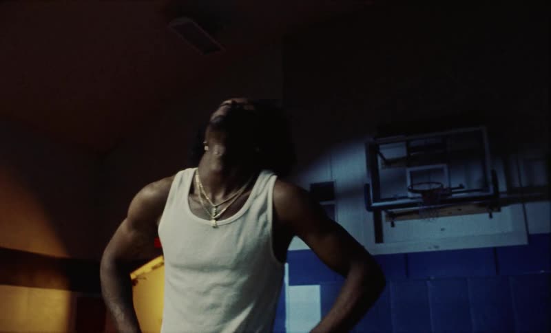 A male is exercising in a gym at night