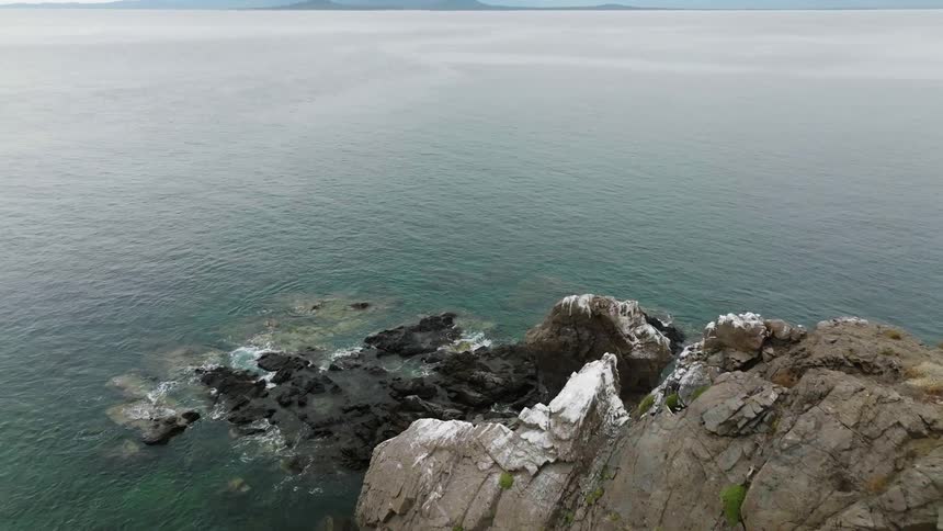 A headland overlooking a rocky coastline during the day