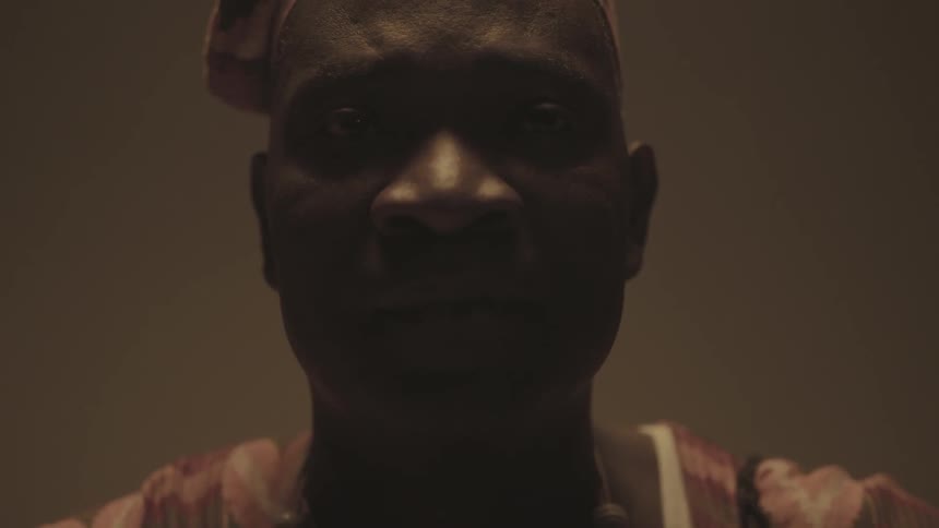 A man is staring forward in a dark area