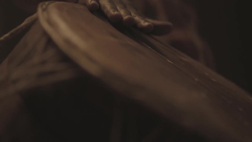 A man traces his hand across a drum