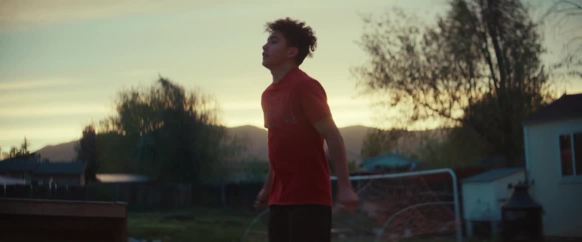 A teenage boy jumps rope outside his home