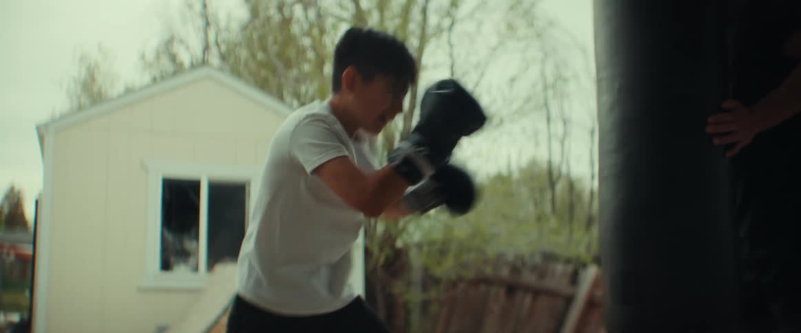 Father teaching his son boxing skills outside