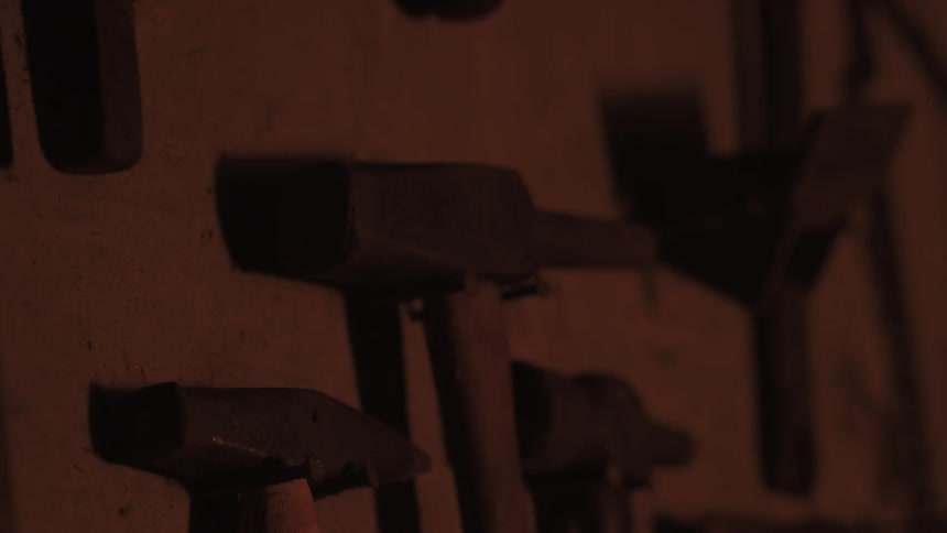Tools hang on the wall of a dark shed