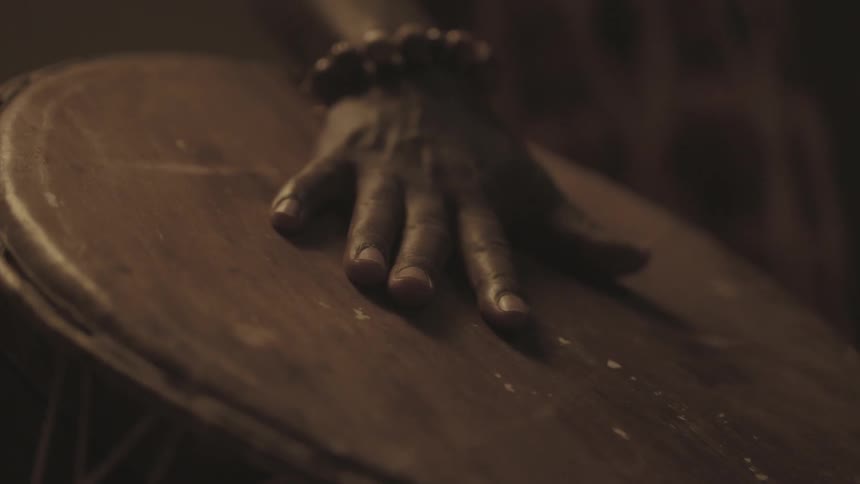 A man running his hand over a bongo