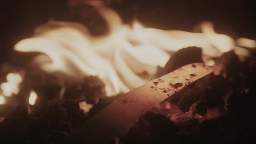 The end of a sword sitting in a fire
