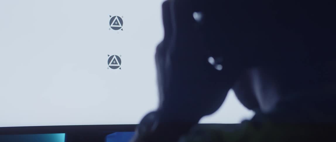 Close up of the back of the head of a man putting on a headset in front of a white replaceable screen